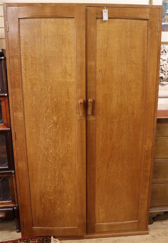 A panelled oak wardrobe and a matching night stand (reputed to be the work of John Skelton) Wardrobe W.107cm